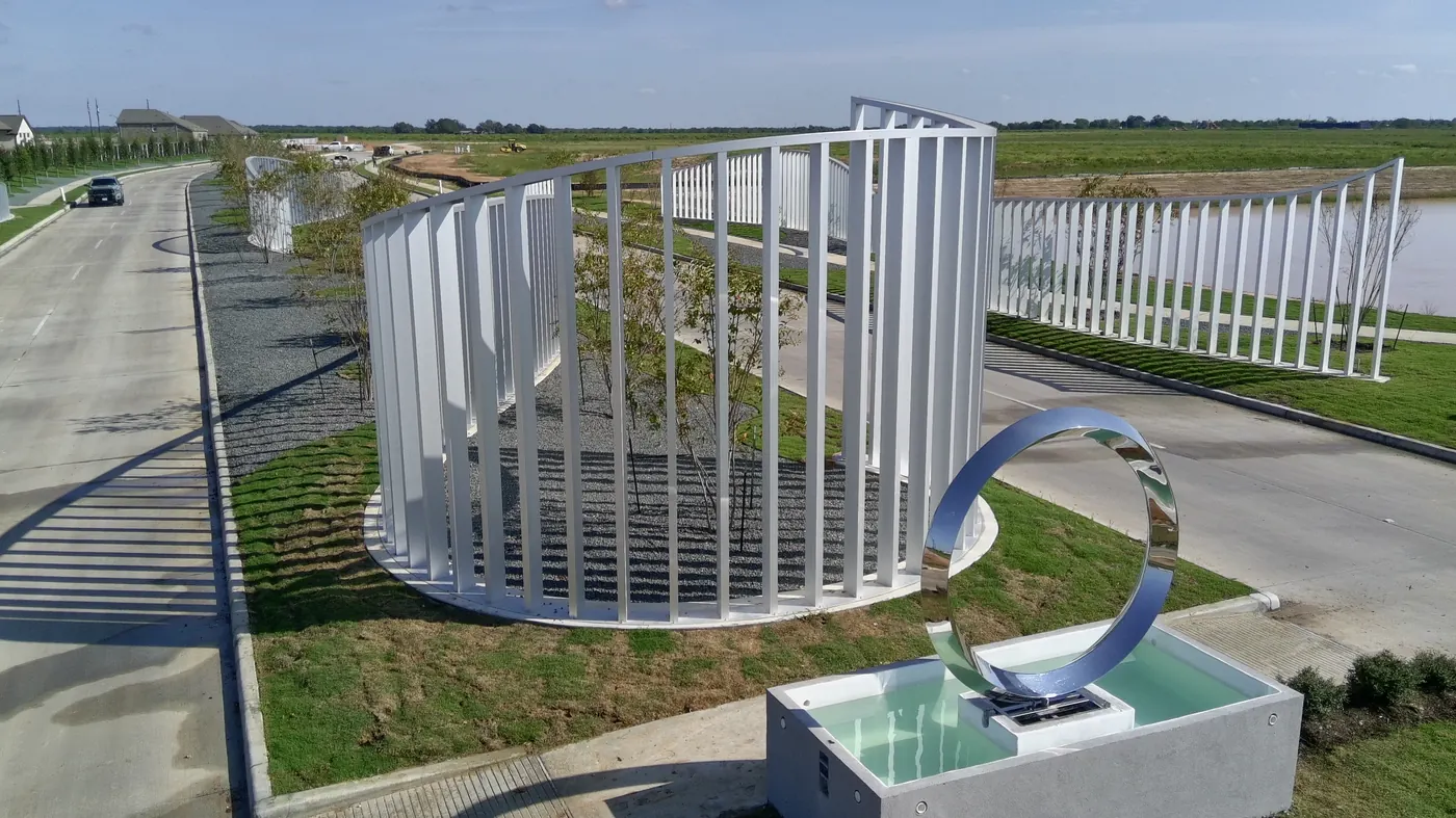 Stainless steel ring sculpture over a water basin at the Sofi Lakes entrance in Katy, TX